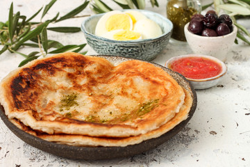 Mediterranean breakfast contains of eggs,bread, olives and tomato sauce