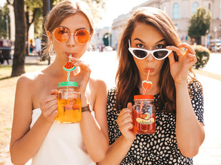 Two young beautiful smiling hipster girls in trendy summer clothes,dress.Sexy carefree women posing...