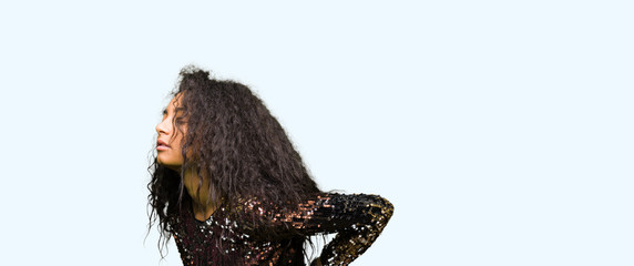 Young beautiful girl with curly hair wearing night party dress Suffering of backache, touching back with hand, muscular pain