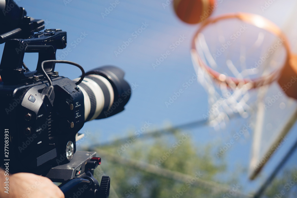 Wall mural Blurry image of movie shooting or video production and film crew team with camera equipment at outdoor location and light flare effect.