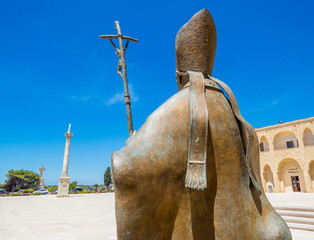 SANTA MARIA DI LEUCA, ITALY - JULY 17, 2017: Pope Benedict XVI bronze statue with view on the main...