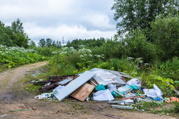 The unauthorized dump of garbage among the wild nature near the industrial and living areas