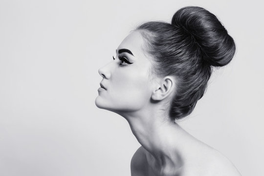 Vintage style black and white profile of young beautiful girl with fancy hair bun