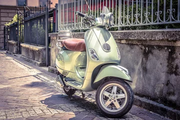 Rollo Roller auf der alten Straße geparkt. Foto im Vintage-Stil. Motorrad ist eines der beliebtesten Verkehrsmittel in Europa. © scaliger