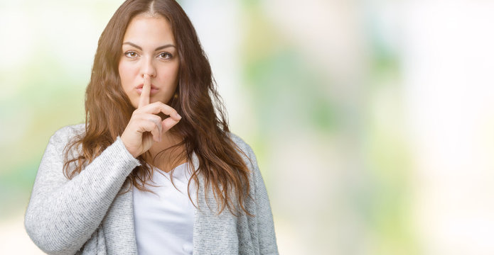 Beautiful plus size young woman wearing winter jacket over isolated background asking to be quiet with finger on lips. Silence and secret concept.