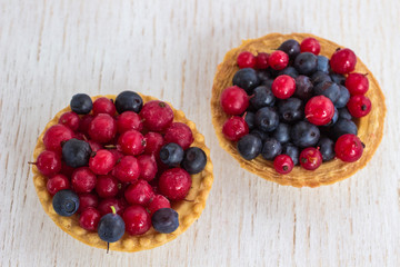 Basket-shaped cookies with with red currants and blueberries  berries. White background.