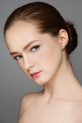 Portrait of young beautiful girl with clean makeup and hair bun
