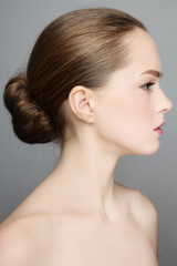 Profile portrait of young beautiful girl with hair bun