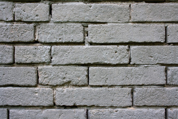 An old, damaged wall of gray bricks - a wabi-sabi style background