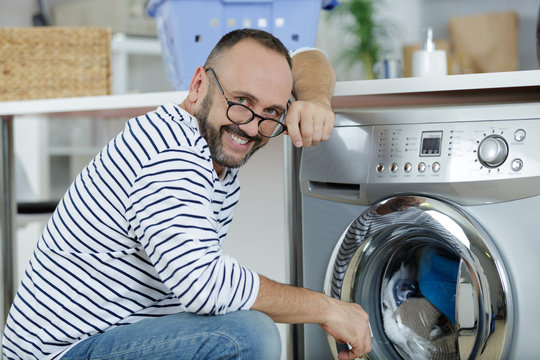 Man Loading Washing Machine With Clothes