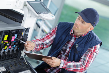 serviceman working on an industrial photocopier