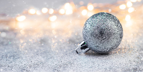Silver brilliant christmas ball on glitter background. Christmas and happy new year concert for your design with space for text, banner. Wallpaper 2020 new year.