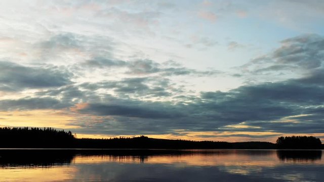 Beautiful View Over Norra Fl&auml;t Lake in Sweden. The Sun is Going Down, and Lights up the Sky with a Scenic Orange Color, You Can See the Reflection of the Sky in the Water.