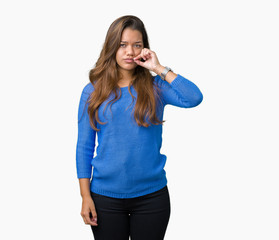Young beautiful brunette woman wearing blue sweater over isolated background mouth and lips shut as...