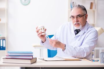 Aged male doctor with skeleton 