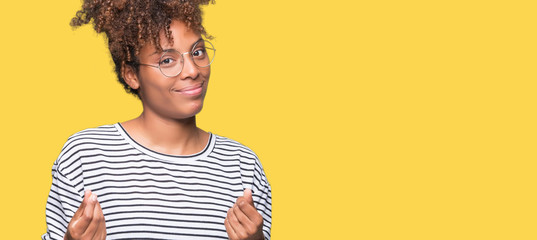 Beautiful young african american woman wearing glasses over isolated background Doing money gesture...
