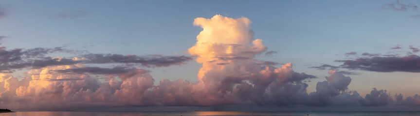 Fototapeta na wymiar Dramatic View of a cloudscape over the Ocean during a dark, rainy and colorful morning sunrise. Taken over Beach Ancon in Trinidad, Cuba.