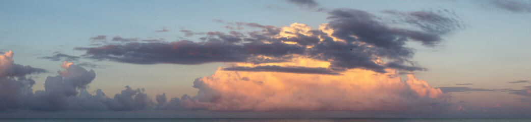Dramatic View of a cloudscape over the Ocean during a dark, rainy and colorful morning sunrise. Taken over Beach Ancon in Trinidad, Cuba.
