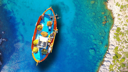 Aerial drone top view photo of red wooden traditional fishing boat in deep turquoise sea shore of Lefkada island, Ionian, Greece