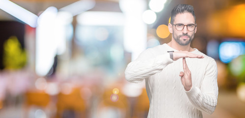 Young handsome man wearing glasses over isolated background Doing time out gesture with hands, frustrated and serious face