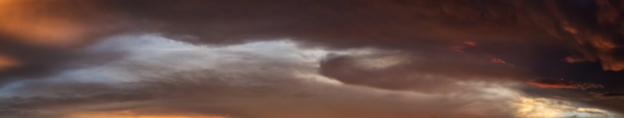 Dramatic Panoramic View of a cloudscape during a dark and colorful sunset. Taken over Beach Ancon...