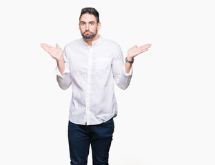 Young business man over isolated background clueless and confused expression with arms and hands...