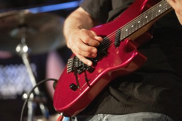 Man lead guitarist playing electrical guitar on concert stage .