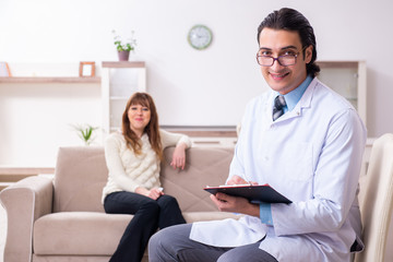 Young female patient discussing with male psychologist personal 