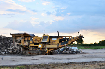 Mobile Stone crusher machine by the construction site or mining quarry for crushing old concrete slabs into gravel and subsequent cement production