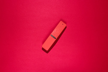 TV remote in a silicone case on red background.