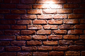Spotlight above the Brick wall. Brick wall texture. Red brick wallpaper. Background Red Brick House Wall Texture Closeup. Red brick wall with a single light from above.