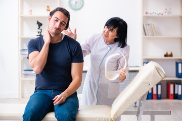 Obraz premium Young male patient visiting aged female doctor 