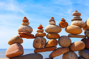 Lots of balanced, colorful stones on a beach on the background of the sea