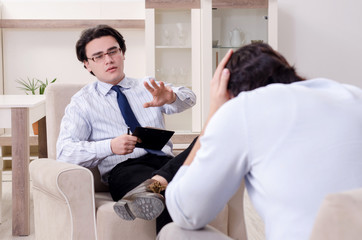 Obraz premium Young male patient discussing with psychologist personal problem