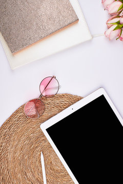 feminin blogger holiday flatlay topview with pink flowers sunglasses ipad basket background golden notebooks