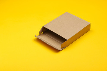 Empty cardboard box on yellow paper background