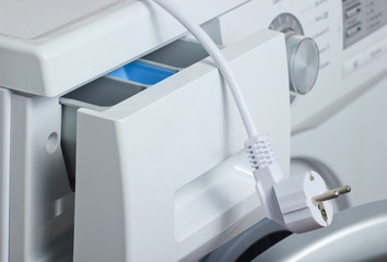 Fragment of a washing machine close-up with electric plug