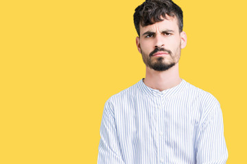 Fototapeta premium Young handsome business man over isolated background skeptic and nervous, disapproving expression on face with crossed arms. Negative person.
