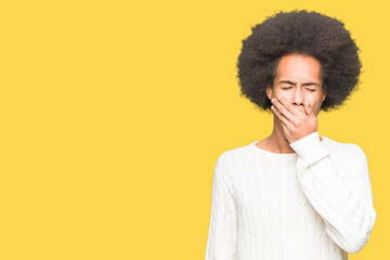 Obraz na płótnie Canvas Young african american man with afro hair wearing winter sweater bored yawning tired covering mouth with hand. Restless and sleepiness.