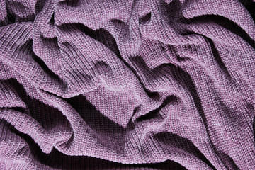 Texture of crumpled purple knitted. Top view