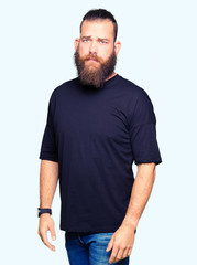 Obraz premium Young blond man wearing casual t-shirt depressed and worry for distress, crying angry and afraid. Sad expression.