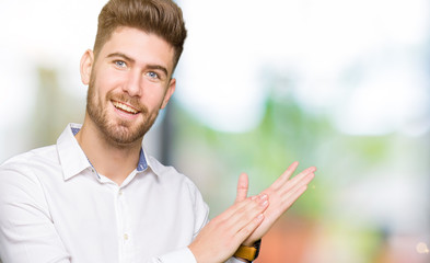 Young handsome business man Clapping and applauding happy and joyful, smiling proud hands together