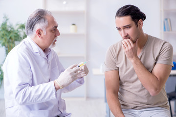 Obraz premium Male patient visitng doctor for shot inoculation 
