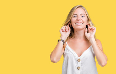 Beautiful young woman over isolated background Smiling pulling ears with fingers, funny gesture. Audition problem