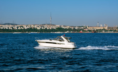 Muslim architecture and water transport in Turkey - Beautiful View touristic landmarks from sea voyage on Bosphorus. Cityscape of Istanbul at sunset - old mosque and turkish steamboats, view on Golden