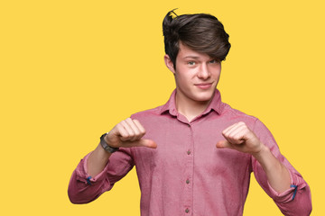 Young handsome business man over isolated background looking confident with smile on face, pointing...