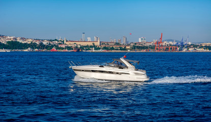 Muslim architecture and water transport in Turkey - Beautiful View touristic landmarks from sea voyage on Bosphorus. Cityscape of Istanbul at sunset - old mosque and turkish steamboats, view on Golden