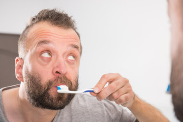 Man brushing his teeth in bathroom