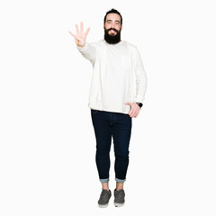 Young man with long hair and beard wearing sporty sweatshirt showing and pointing up with fingers number four while smiling confident and happy.