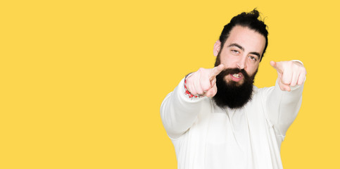 Young hipster man with long hair and beard wearing sporty sweatshirt Pointing to you and the camera with fingers, smiling positive and cheerful